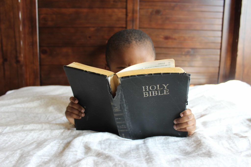 Kid Praying and Reading Bible